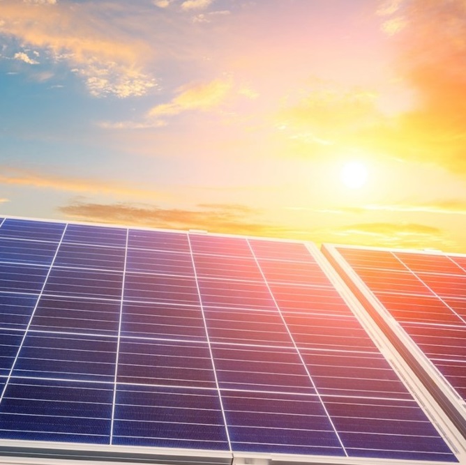 Solceller på tak i solnedgang